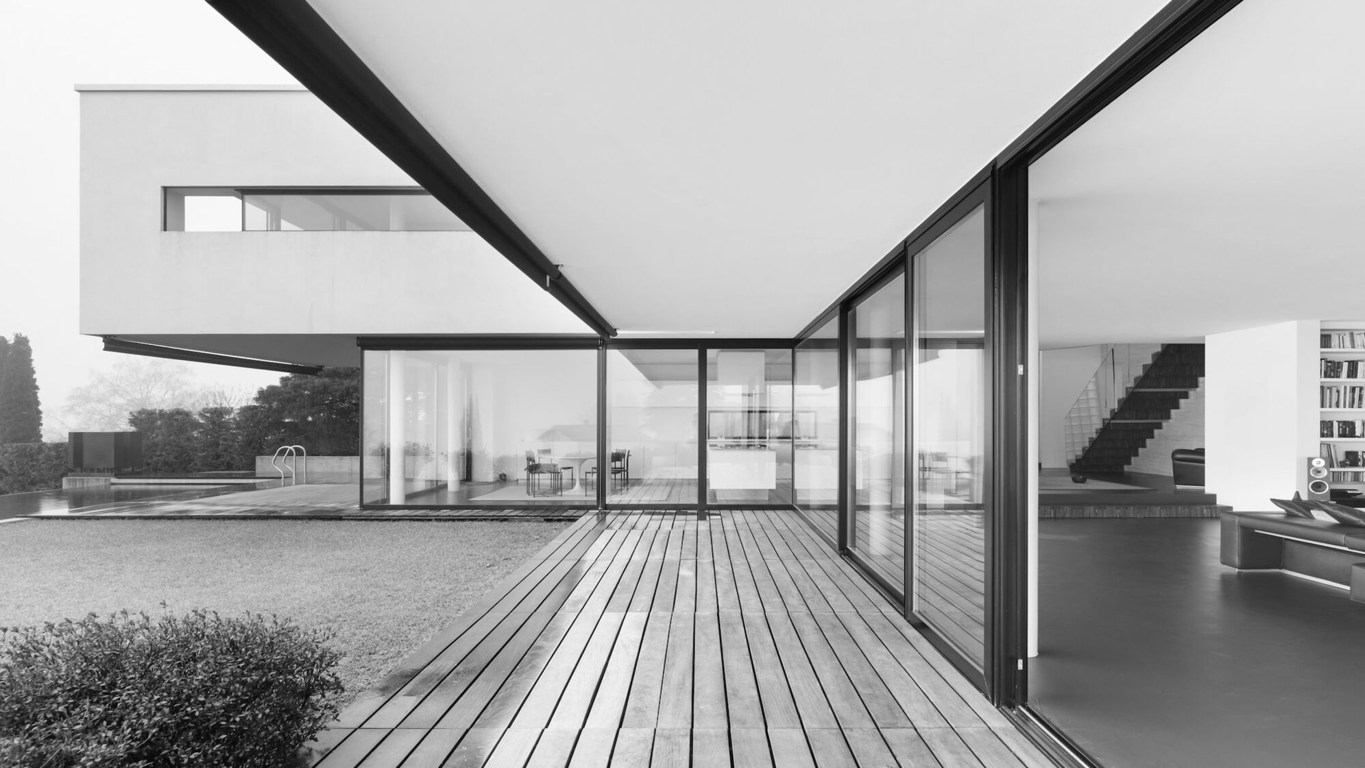 Schwarz und Weißes Bild einer modernen Terrasse aus Holz mit großer Fensterfront